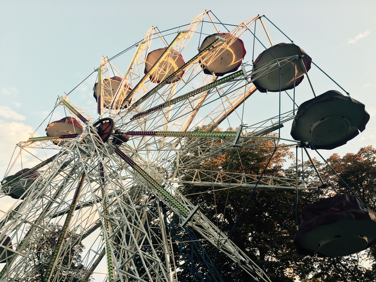 A Ferris wheel seen from below at golden hour