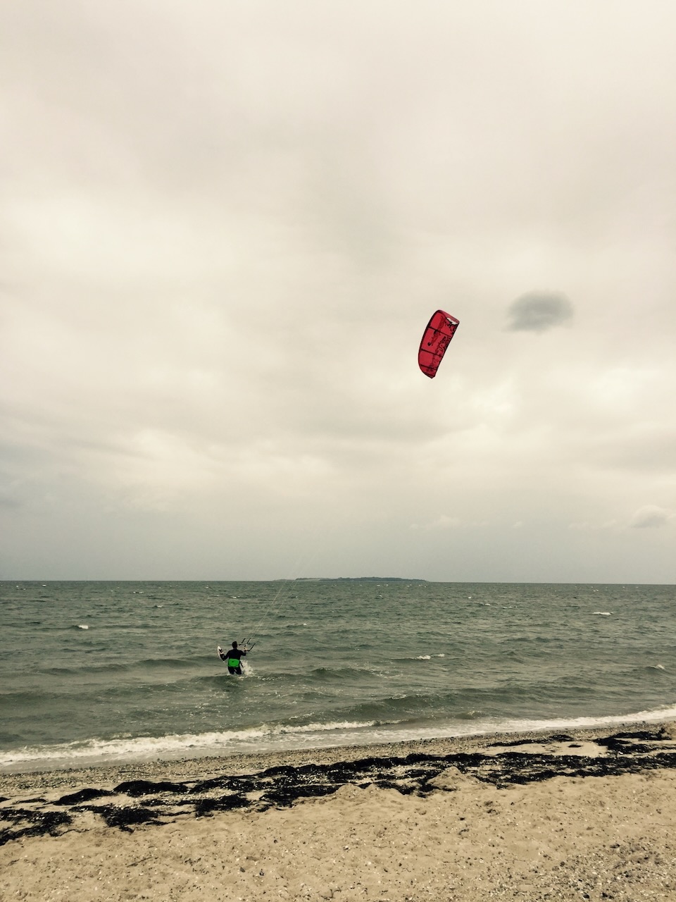 A kitesurfer heading into a rough sea